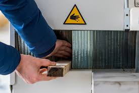 A man places his hand into a machine with a warning sign.